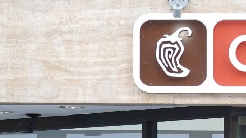 imagen de la fachada de un restaurante Chipotle y una persona en el apaador.