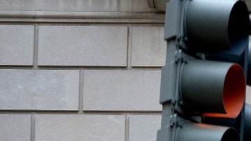 Facha del edificio del IRS con un letrero que indica el nombre de la oficina y unos semáforos.