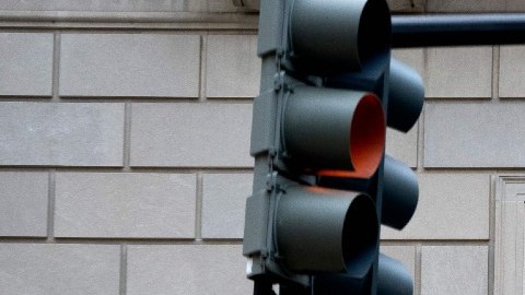 Facha del edificio del IRS con un letrero que indica el nombre de la oficina y unos semáforos.