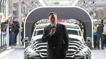 Elon Musk con un micrófono en la mano y parado frente a un vehículo Model 3 de Tesla, en la fábrica de Berlín, Alemania.