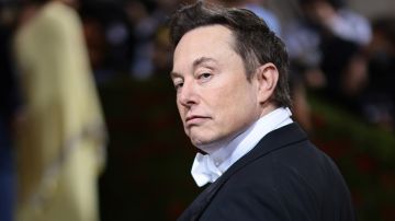 Elon Musk con un traje frac y mirando sobre su hombro