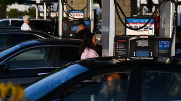 Imagen de varias personas esperando en la fila de una estación de servicio para cargar gasolina.