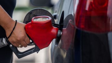 Una persona carga gasolina a su automóvil en una estación de servicio.