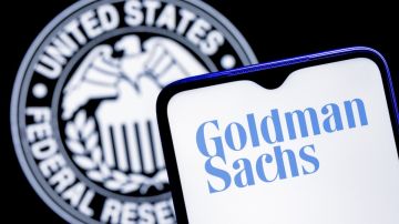 un celular con el logotipo de Goldman Sachs y un sello de la Reserva Federal en el fondo
