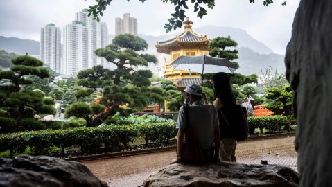 Imagen de un parque en Hong Kong con edificios tradicionales y modernos en el fondo.