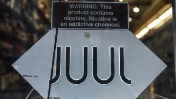 Un letrero de Juul lab en una tienda de productos de tabaco, con un anuncio de advertencia sobre el contenido de nicotina.