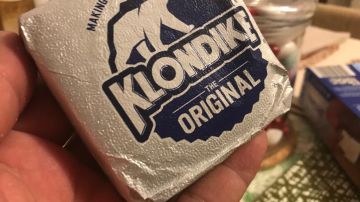 Una barra de helado de la marca Klondike es mostrada por una mano.