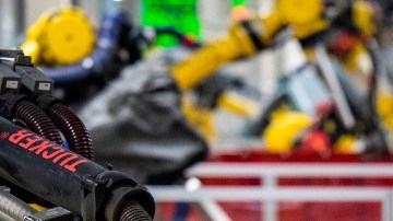 Imagen de dos brazos robóticos en una línea de producción