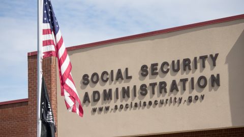 Fachada de una oficina del Seguro Social y de una bandera de Estados Unidos.