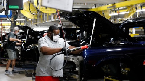 una persona que trabaja en una fábrica armadora de autos