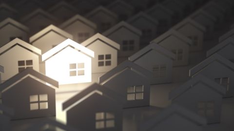 Imagen de varias casas de papel juntas y una iluminada.
