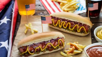 Dos hotdogs con banderas de los Estados Unidos , cerveza y papas fritas.