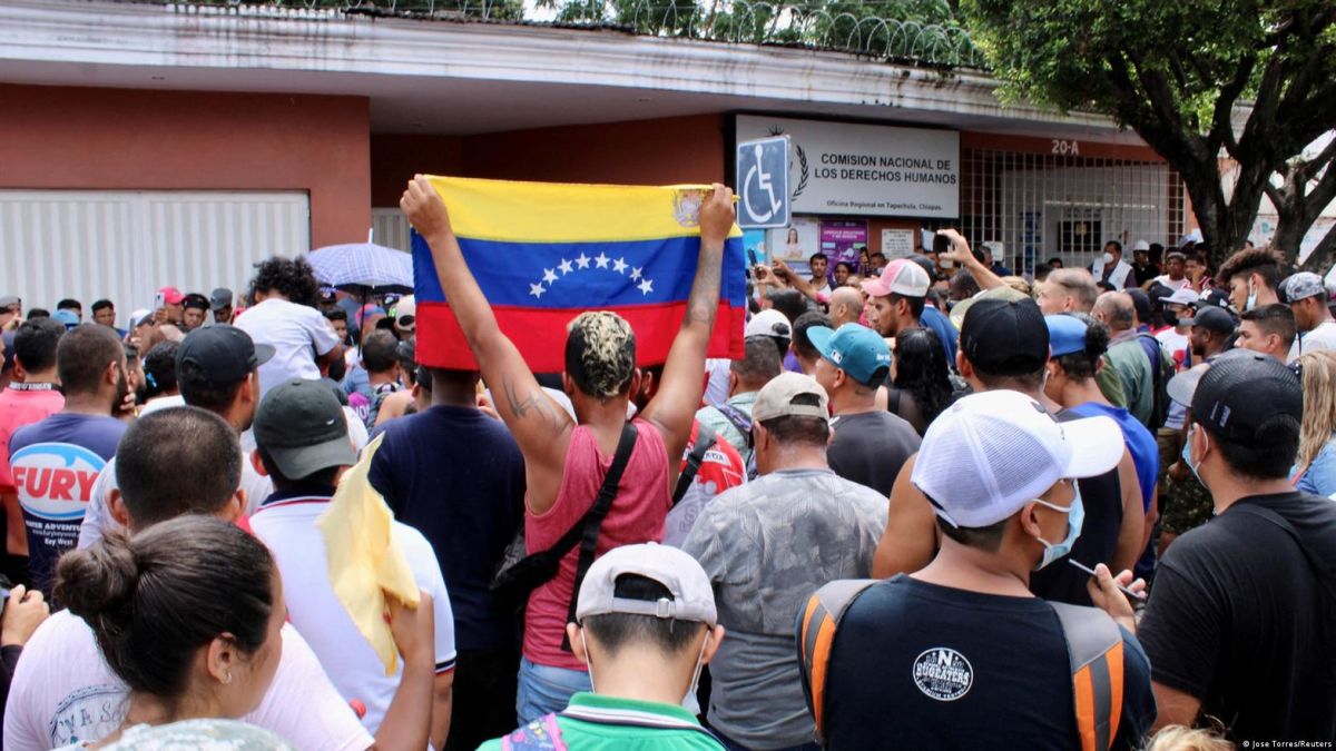 En señal de solicitud de ayuda un migrante levanta una bandera de Venezuela frente a la oficina de la Comisión Nacional de Derechos Humanos de Tapachula, México