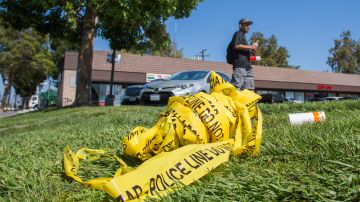 A bundle of police crime scene tape is left on front of the 7-eleven shop in Santa Ana, California on August 08, 2019 where a security guard was fatally stabbed. - Police said the suspect, Zachary Castaneda, a 33-year-old resident of Garden Grove used multiple knives or machetes in the attacks that started yesterday afternoon. (Photo by Apu Gomes / AFP) (Photo credit should read APU GOMES/AFP via Getty Images)