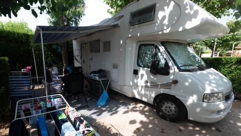 People sit outside their motorhome at a campsite in Peniscola near Castellon on July 8, 2020. - With social distancing now the new norm across Europe to avoid any fresh outbreaks, there has been a shift in thinking about holidays. Across Europe, there has been growing interest in the motorhome sector and today. (Photo by JOSE JORDAN / STR / AFP) (Photo by JOSE JORDAN/STR/AFP via Getty Images)