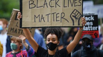 Las personas sostienen pancartas en apoyo del movimiento Black Lives Matter mientras participan en la marcha inaugural Million People March desde Notting Hill hasta Hyde Park en Londres el 30 de agosto de 2020, para presionar al gobierno del Reino Unido a cambiar el "Reino Unido institucional y el racismo sistémico".