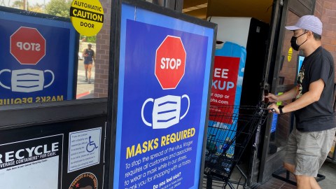 People shop at a grocery store enforcing the wearing of masks in Los Angeles on July 23, 2021. - With the Delta variant pushing US Covid cases back up, fully vaccinated people are wondering whether they need to start masking indoors again. Covid vaccines remain extremely effective against the worst outcomes of the disease -- hospitalization and death -- and breakthrough infections remain uncommon. (Photo by Chris Delmas / AFP) (Photo by CHRIS DELMAS/AFP via Getty Images)