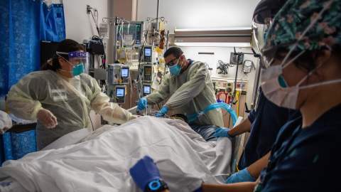 Health care workers attend to a patient with Covid-19 as they prepare to turn the 45 year old unvaccinated patient from his stomach onto his back at the Cardiovascular Intensive Care Unit at Providence Cedars-Sinai Tarzana Medical Center in Tarzana, California on September 2, 2021. - According to Dr. Yadegar at the hospital, the number of covid patients are significantly less than they were in winter, but from a psychological standpoint it's much more difficult because most of the patients in the ICU on respirators are unvaccinated, younger and healthier 30 and 40 year olds without comorbidities. Vaccinated patients at the hospital are typically older, but the Covid-19 effects are much milder compared to the unvaccinated patients that have more severe symptoms. (Photo by Apu GOMES / AFP) (Photo by APU GOMES/AFP via Getty Images)