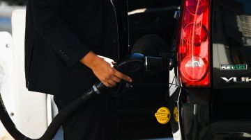 A customer pumps gasoline into an sport utility vehicle (SUV) at a Shell gas station in the Chinatown neighborhood of Los Angeles, California, on February 17, 2022. - In Los Angeles County, a new record for gas prices has now been set for the 11th time in 12 days. The average price of a gallon of self-serve regular is now $4.77 per gallon, up more than 10 cents over the past 16 days. (Photo by Patrick T. FALLON / AFP) (Photo by PATRICK T. FALLON/AFP via Getty Images)