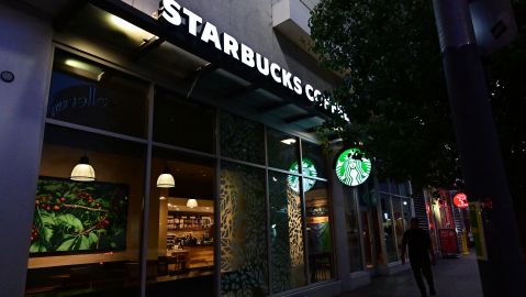 A pedestrian walks past a Starbucks closed for the day in Los Angeles, California on July 12, 2022. - Starbucks will close six locations in Los Angeles, including this one in downtown, by the end of the month. Company officials cite safety concerns for workers and customers as issues facing the nation, from racism to lack of access to health care to a growing mental health crisis, impact the coffee chain. (Photo by Frederic J. BROWN / AFP) (Photo by FREDERIC J. BROWN/AFP via Getty Images)