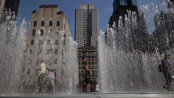 La gente se refresca en una fuente instalada en Rockefeller Center Plaza en Nueva York.