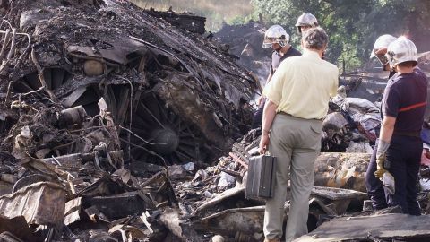 Una foto de archivo tomada el 26 de julio de 2000 en Gonesse, muestra a los bomberos franceses mirando dos motores del avión Concorde, un día después de que el vuelo de Air France AF4590 se estrelló contra un hotel Gonesse, matando a 113 personas.