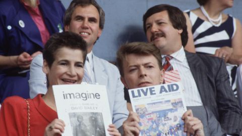 El cantante David Bowie (David Jones) con un amigo en el concierto 'Live Aid' en el estadio de Wembley, Londres. David Bowie sostiene una copia del programa Live Aid