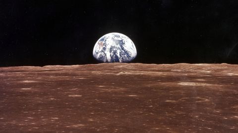 Una vista de la Tierra aparece sobre el horizonte lunar cuando el Módulo de Comando del Apolo 11 entra a la vista de la Luna antes de que Astronatus Neil Armstrong y Edwin Aldrin Jr. se vayan en el Módulo Lunar, Eagle, para convertirse en los primeros hombres a caminar sobre la superficie de la Luna.