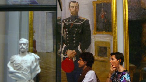 La gente pasa por una pintura y una escultura del difunto zar ruso Nicolás II mientras visitan el 10 de julio de 2009 en Mónaco, la exposición "Moscou, Slendeur des Romanov" (Moscú, el esplendor de Romanov) en la víspera de su inauguración en el Foro Grimaldi en Mónaco.