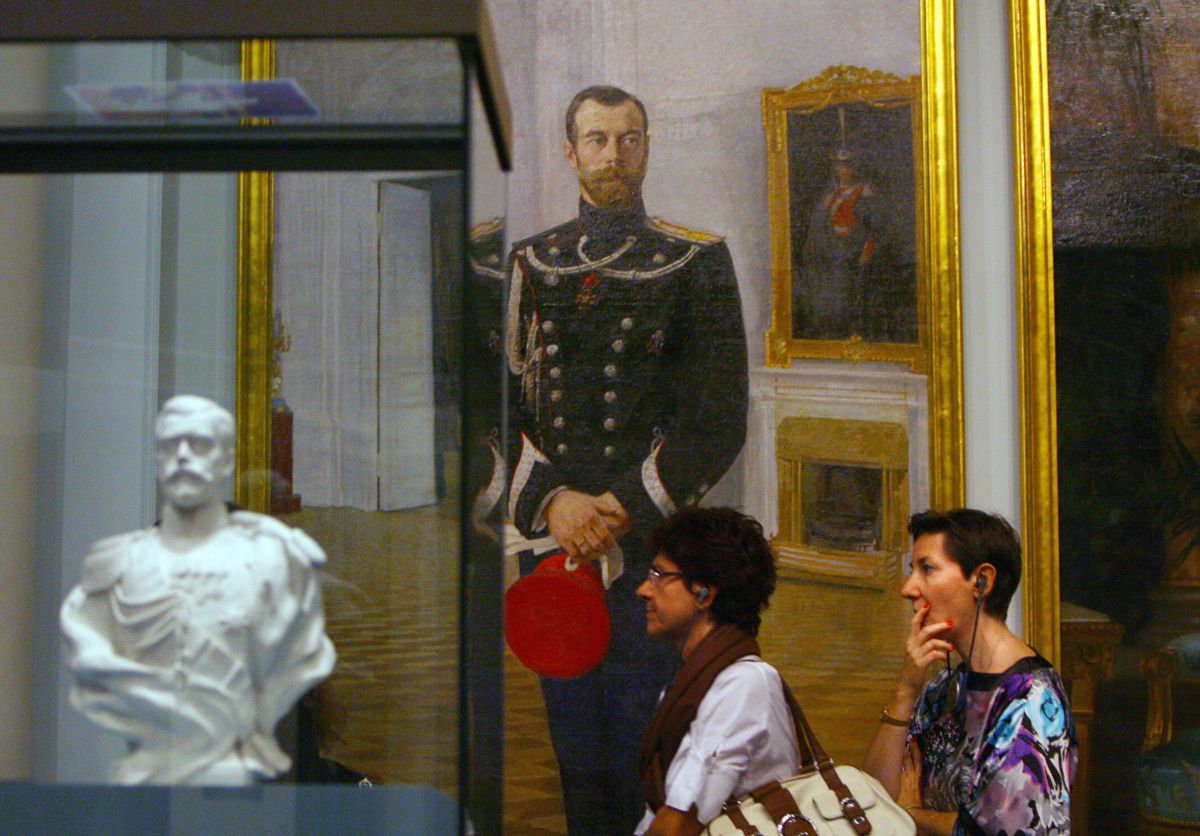 La gente pasa por una pintura y una escultura del difunto zar ruso Nicolás II mientras visitan el 10 de julio de 2009 en Mónaco, la exposición "Moscou, Slendeur des Romanov" (Moscú, el esplendor de Romanov) en la víspera de su inauguración en el Foro Grimaldi en Mónaco.