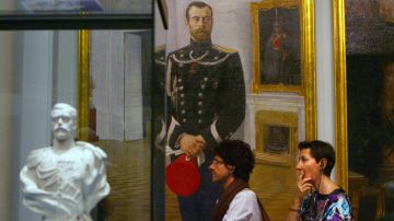 La gente pasa por una pintura y una escultura del difunto zar ruso Nicolás II mientras visitan el 10 de julio de 2009 en Mónaco, la exposición "Moscou, Slendeur des Romanov" (Moscú, el esplendor de Romanov) en la víspera de su inauguración en el Foro Grimaldi en Mónaco.