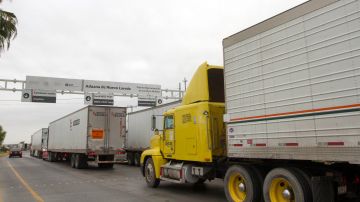 Camiones de carga comercial cruzan el Puente Internacional de Comercio Mundial entre Nuevo Laredo, en México, y Laredo en EE.UU.