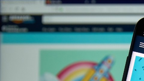 Imagen de una persona que muestra la pantalla de un teléfono móvil que muestra en la pantalla letras de Amazon Prime Day.