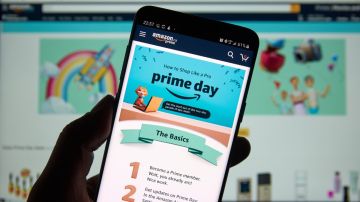 Imagen de una persona que muestra la pantalla de un teléfono móvil que muestra en la pantalla letras de Amazon Prime Day.