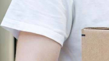 Una persona carga una caja de Amazon.