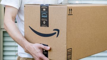 Una persona carga una caja de Amazon.