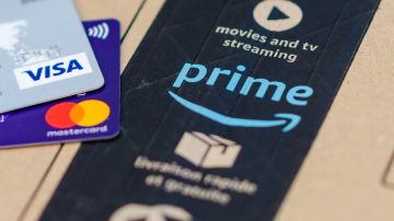 Imagen de dos tarjetas de crédito o débito sobre una caja de cartón de Amazon.