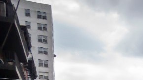 Una camioneta de color azul oscuro con los logotipos de Amazon da vuelta en una calle.