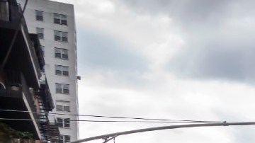 Una camioneta de color azul oscuro con los logotipos de Amazon da vuelta en una calle.