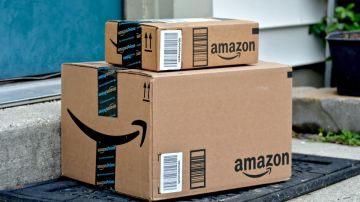 Dos cajas de cartón de Amazon apiladas frente a la puerta de una casa.