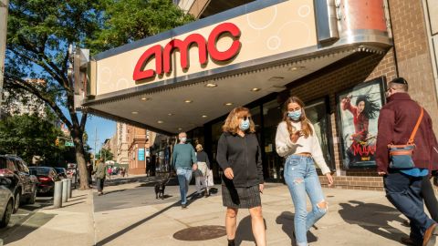 Personas que caminan frente a un cine de la cadena AMC.