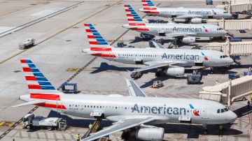 Cuatro aviones de American Airlines en posiciones en un aeropuerto.