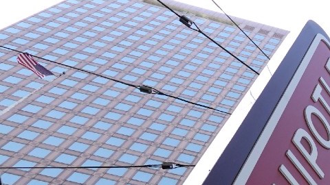 Un letrero luminoso de la marca de comida rápida Chipotle se ve colocado en la fachada de un edificio.