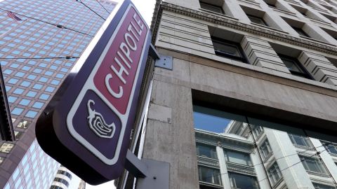 Un letrero luminoso de la marca de comida rápida Chipotle se ve colocado en la fachada de un edificio.