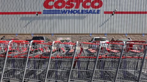 Carritos de compra de Costco apilados frente a un almacén en el que se ve la marca de esta tienda.