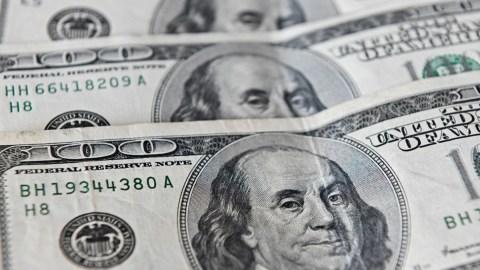 Imagen de billetes de $100 dólares colocados uno sobre otro.