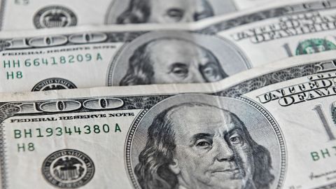 Imagen de billetes de $100 dólares colocados uno sobre otro.