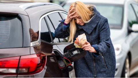 mujer angustiada contra un auto