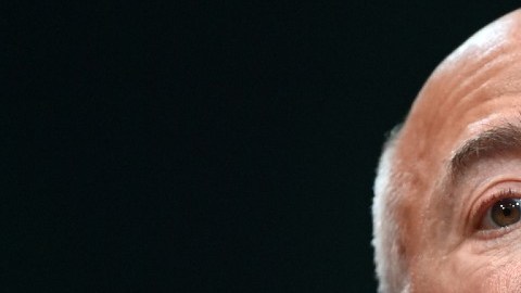 Imagen de Jeff Bezos, vestido con un traje oscuro y una camisa color azul, parado frente a un estrado con dos micrófonos.