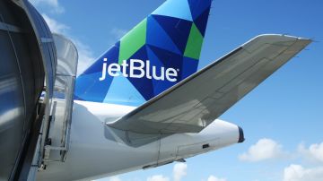 Una rampa se ve que da acceso a la puerta trasera de un avión de la aerolínea JetBlue.